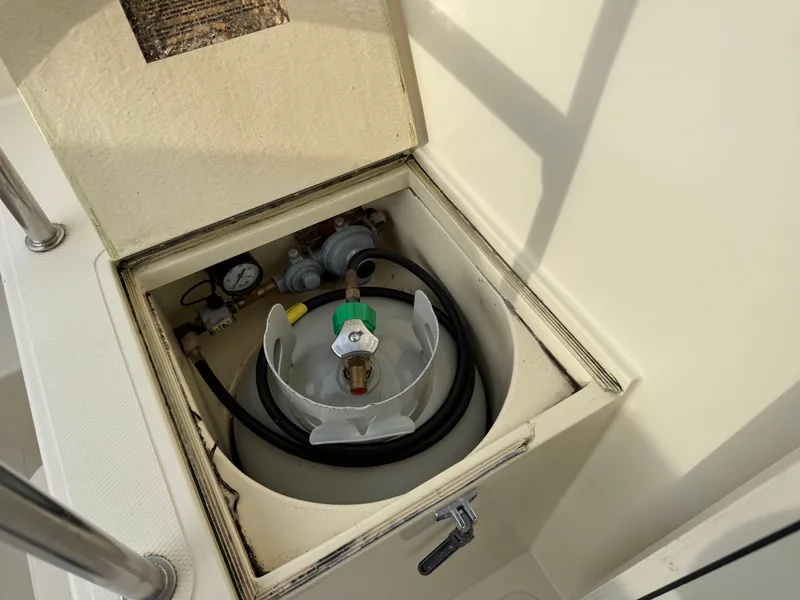 Slide: The Image of Propane tank compartment on a 2003 Camano Troll boat, featuring a gauge and regulator. - 30