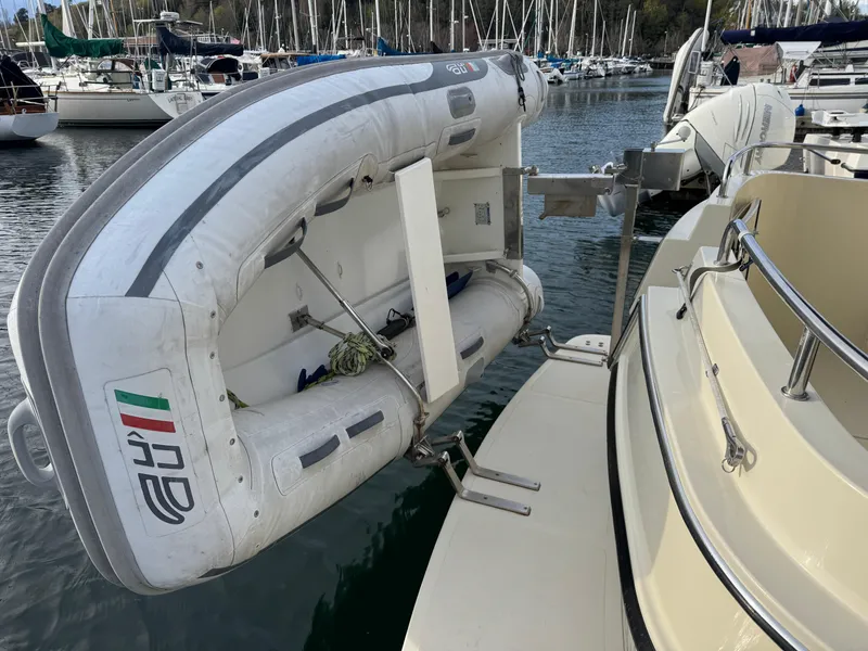 Slide: The Image of Inflatable dinghy mounted on a 2003 Camano Troll boat at a marina. - 4