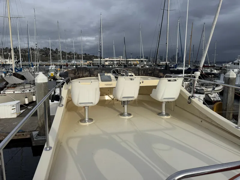 Slide: The Image of 2003 Camano Troll boat with three seats docked at a marina under cloudy skies. - 7