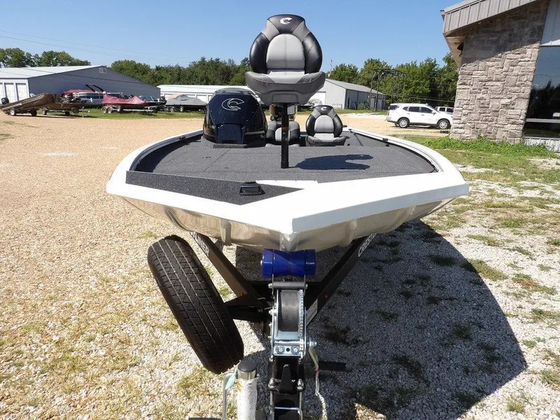 Slide: The Image of 2025 Crestliner XFC 189 boat on trailer, parked outdoors on gravel. - 2