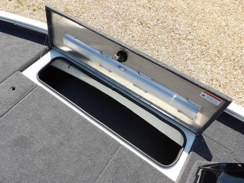 Slide: The Image of Open storage compartment on 2025 Crestliner XFC 189 boat, featuring carpeted interior. - 27