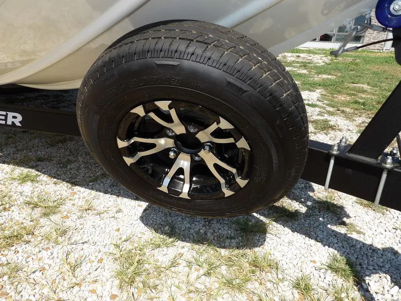 Slide: The Image of Trailer wheel of 2025 Crestliner XFC 189 boat on gravel and grass surface. - 34