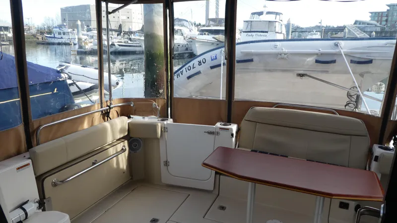 Slide: The Image of 2021 Ranger Tugs R-29 S interior with seating and table, docked at marina. - 12