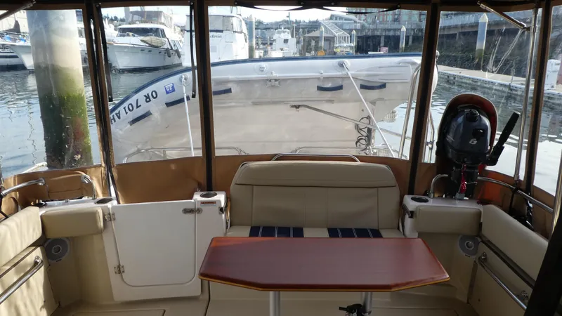 Slide: The Image of 2021 Ranger Tugs R-29 S interior with seating and table, docked at marina. - 13