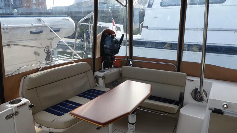 Slide: The Image of 2021 Ranger Tugs R-29 S interior with seating and table, docked at marina. - 14