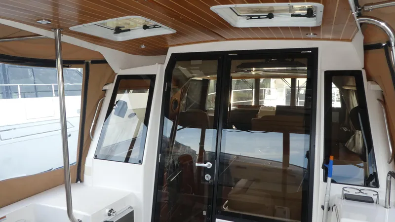 Slide: The Image of 2021 Ranger Tugs R-29 S interior with wood ceiling and glass doors. - 17