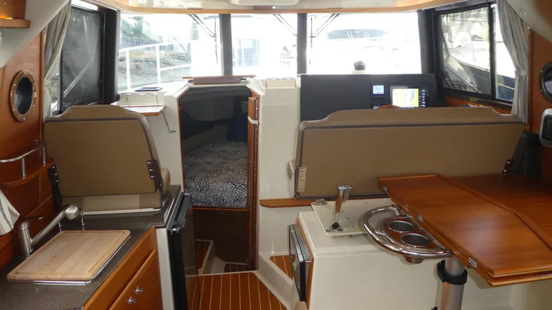 Slide: The Image of 2021 Ranger Tugs R-29 S interior with kitchen, seating, and navigation area. - 19