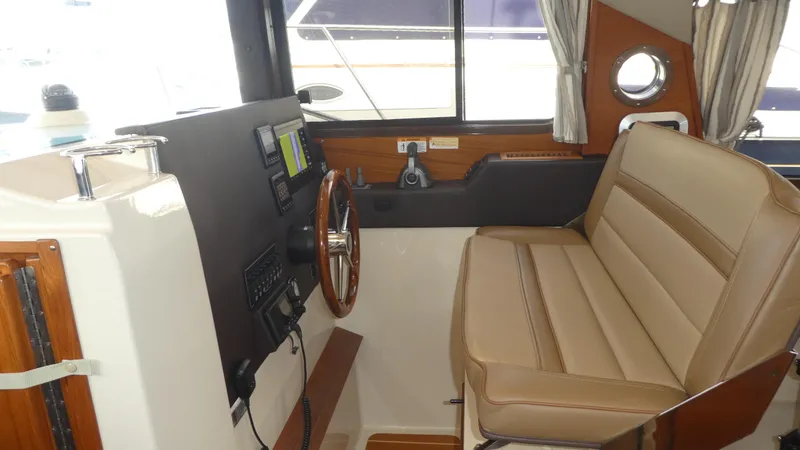 Slide: The Image of 2021 Ranger Tugs R-29 S helm with leather seating and navigation controls. - 21
