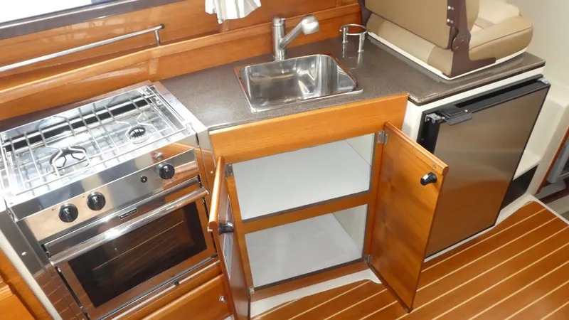 Slide: The Image of 2021 Ranger Tugs R-29 S galley with stove, sink, and refrigerator. - 29