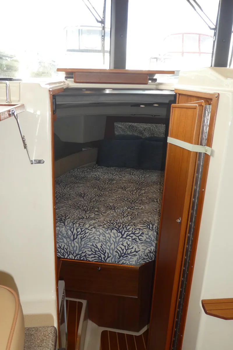 Slide: The Image of 2021 Ranger Tugs R-29 S cabin interior with bed and wooden accents. - 34