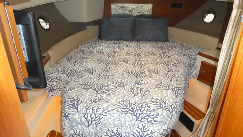 Slide: The Image of Cozy cabin interior of 2021 Ranger Tugs R-29 S with patterned bedding and porthole windows. - 37