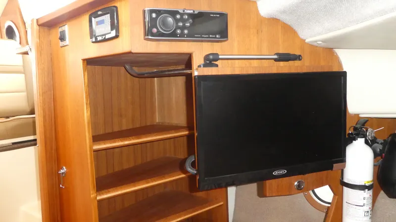 Slide: The Image of 2021 Ranger Tugs R-29 S interior with wooden shelves, TV, and fire extinguisher. - 41