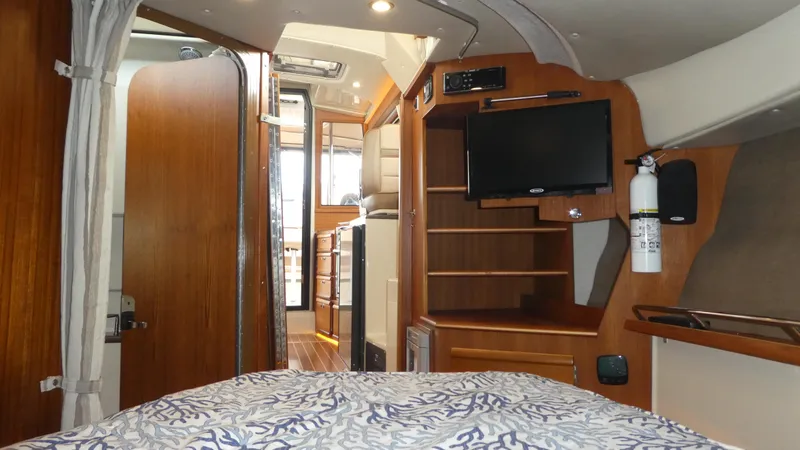 Slide: The Image of Interior of 2021 Ranger Tugs R-29 S, featuring cozy cabin with TV and wooden accents. - 42