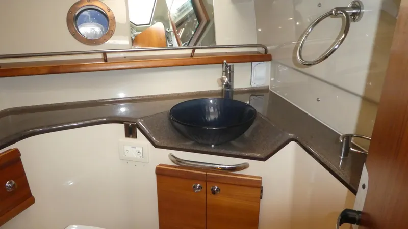 Slide: The Image of 2021 Ranger Tugs R-29 S bathroom with modern sink and wooden cabinetry. - 45