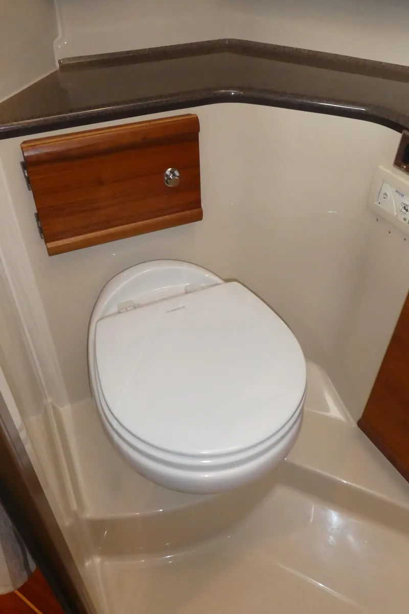 Slide: The Image of 2021 Ranger Tugs R-29 S boat bathroom with modern toilet and wooden accents. - 46