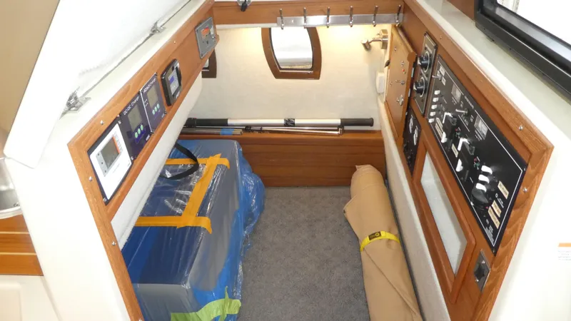 Slide: The Image of 2021 Ranger Tugs R-29 S interior cabin with control panels and storage area. - 50