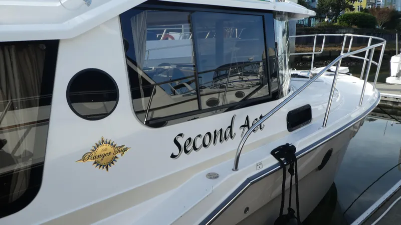 Slide: The Image of 2021 Ranger Tugs R-29 S boat named "Second Act" docked at a marina. - 9