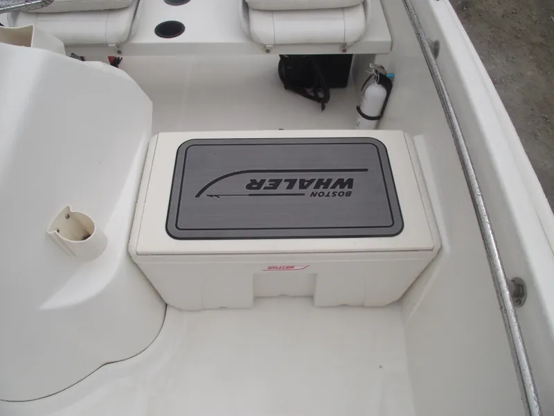 Slide: The Image of 2010 Boston Whaler 150 Super Sport interior with seating and storage compartment. - 11