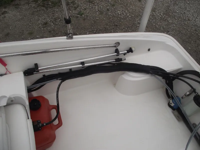 Slide: The Image of 2010 Boston Whaler 150 Super Sport interior with fuel tank and steering cables. - 17