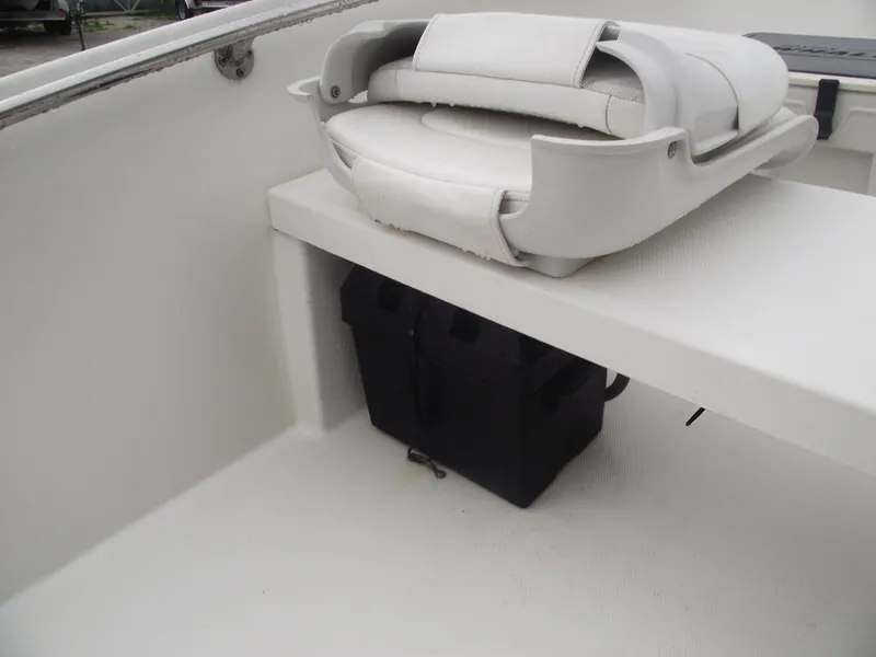 Slide: The Image of 2010 Boston Whaler 150 Super Sport interior with white seating and storage compartment. - 20