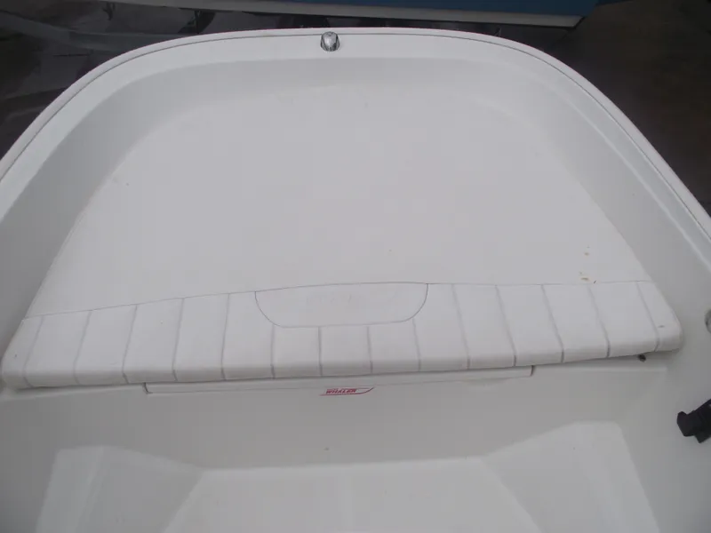 Slide: The Image of 2010 Boston Whaler 150 Super Sport boat interior, featuring a clean, white seating area. - 6