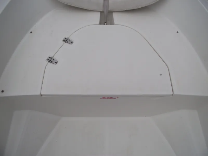 Slide: The Image of 2010 Boston Whaler 150 Super Sport boat interior, featuring a white storage compartment. - 7