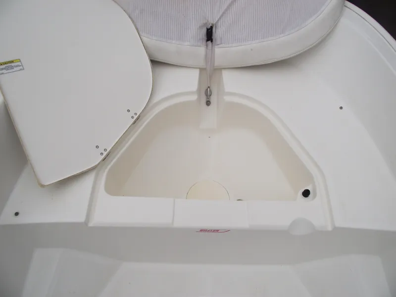 Slide: The Image of 2010 Boston Whaler 150 Super Sport interior detail, featuring storage compartment and seating. - 8