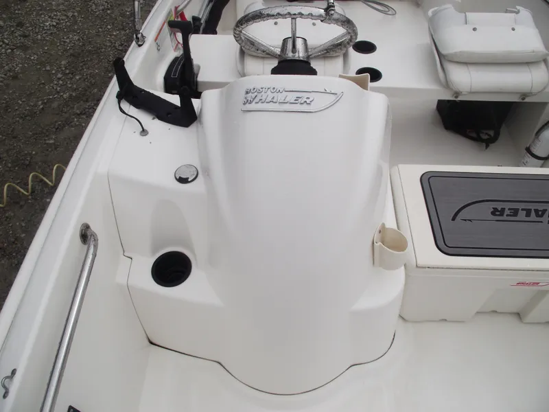 Slide: The Image of 2010 Boston Whaler 150 Super Sport boat interior with steering console and seating. - 9