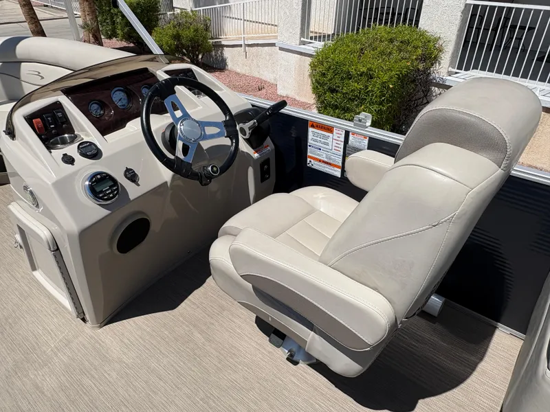 Slide: The Image of 2018 Bennington 22 SSRX boat helm with beige captain's chair and control panel. - 10