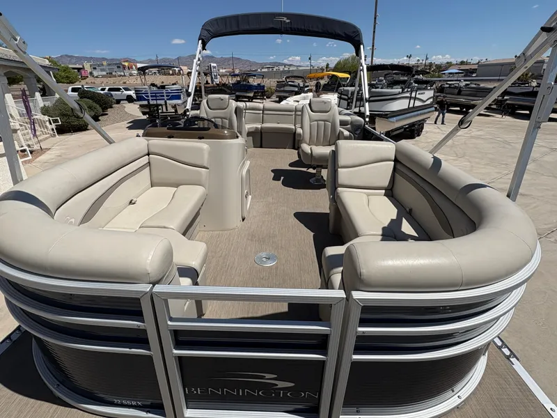 Slide: The Image of 2018 Bennington 22 SSRX pontoon boat with spacious seating and canopy, docked outdoors. - 2
