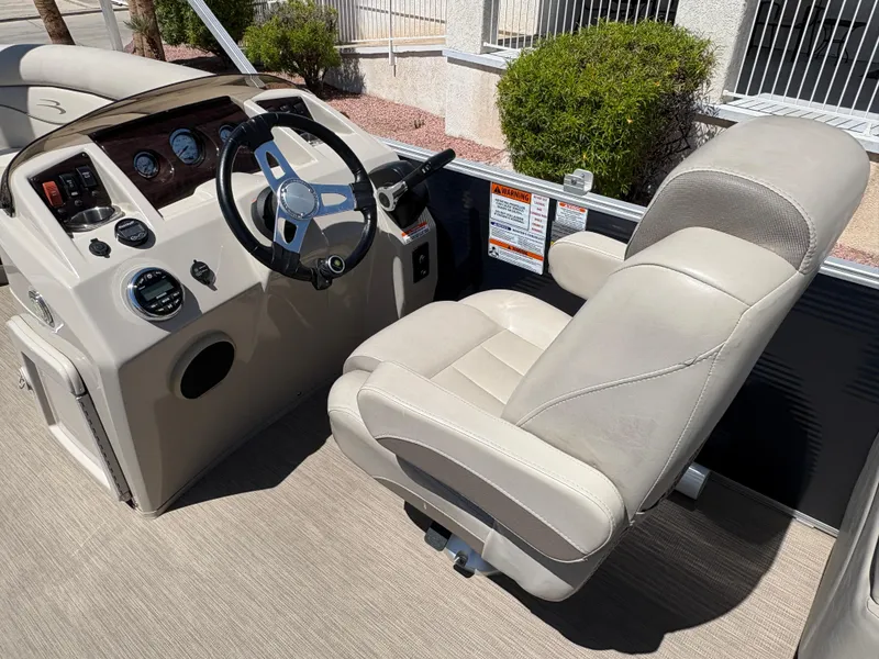 Slide: The Image of 2018 Bennington 22 SSRX boat interior with steering wheel and captain's chair. - 9