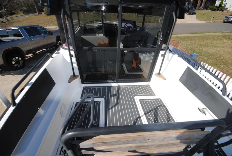 Slide: The Image of 2015 XO Boats 270 RS deck view with seating and cabin entrance. - 11