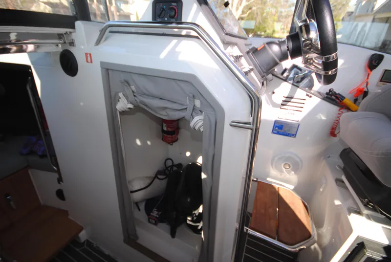 Slide: The Image of Interior of 2015 XO Boats 270 RS showing storage compartment and steering wheel. - 22