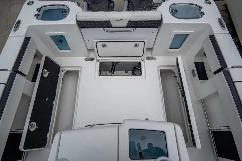 Slide: The Image of 2023 Tidewater 282cc Adventure Bluewater boat interior with storage compartments and seating. - 10