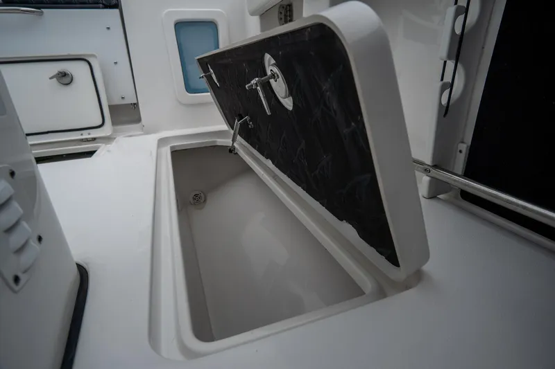 Slide: The Image of 2023 Tidewater 282cc Adventure Bluewater boat storage compartment open. - 12