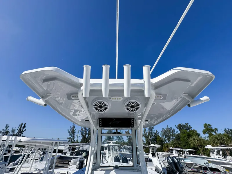 Slide: The Image of 2023 Tidewater 282cc Adventure Bluewater boat with T-top and rod holders under clear sky. - 14