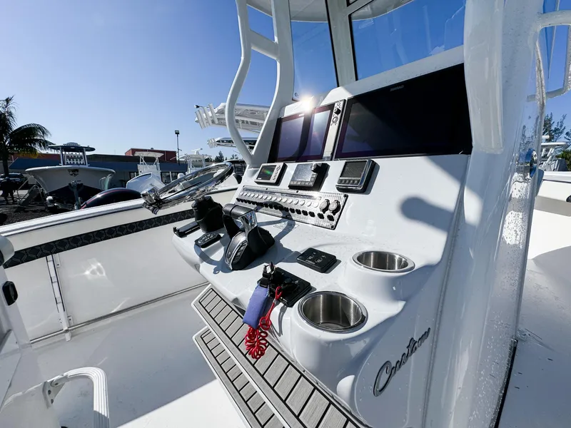 Slide: The Image of 2023 Tidewater 282cc Adventure Bluewater boat console with modern controls and dual screens. - 18