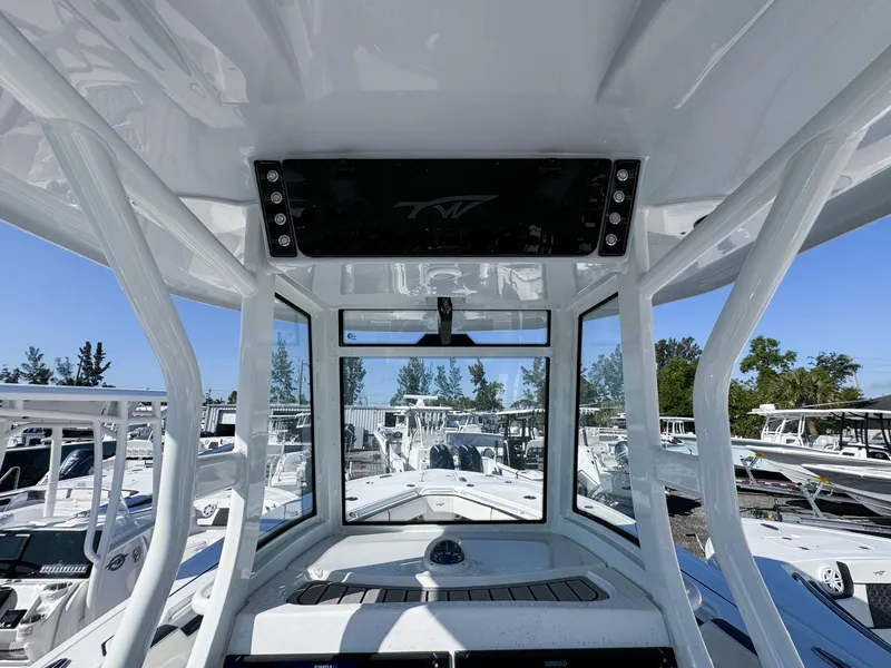 Slide: The Image of 2023 Tidewater 282cc Adventure Bluewater boat interior with console and clear view of marina. - 19