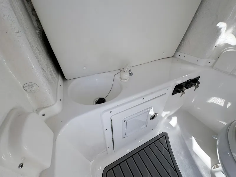 Slide: The Image of 2023 Tidewater 282cc Adventure Bluewater boat interior, featuring storage compartment and clean white finish. - 21