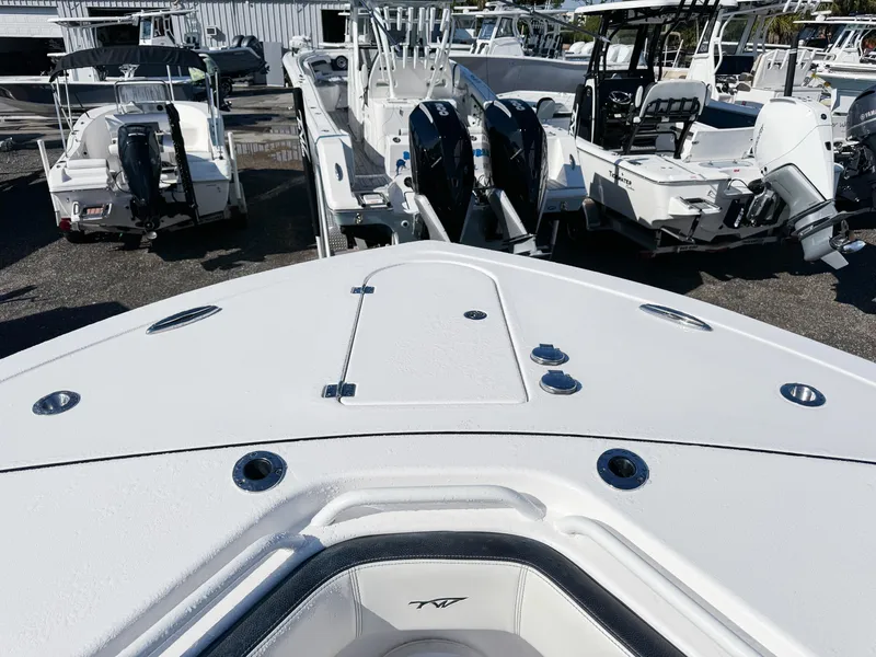 Slide: The Image of 2023 Tidewater 282cc Adventure Bluewater boat, docked with other vessels, showcasing sleek design. - 27
