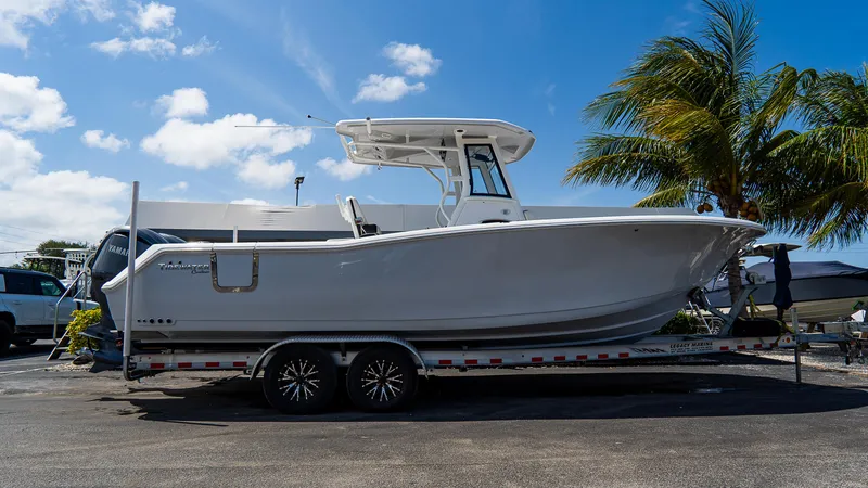 Slide: The Image of 2023 Tidewater 282cc Adventure Bluewater boat on trailer, parked under a clear blue sky. - 28