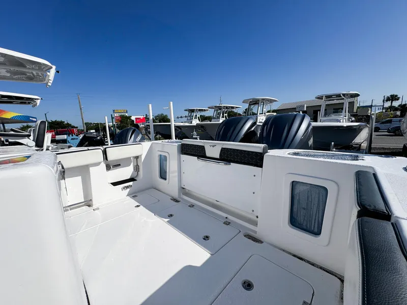 Slide: The Image of 2023 Tidewater 282cc Adventure Bluewater boat interior with seating and storage, under clear blue sky. - 6