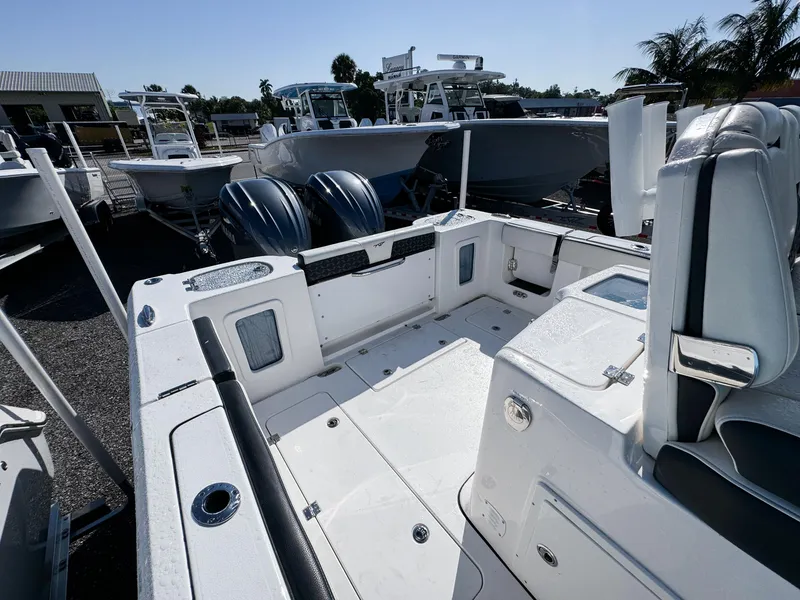 Slide: The Image of 2023 Tidewater 282cc Adventure Bluewater boat interior with dual engines, docked outdoors. - 7