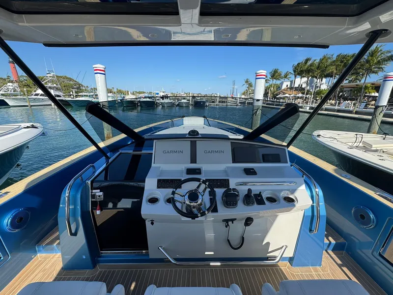 Slide: The Image of 2022 Pardo Yachts 43 helm with modern controls, docked in a sunny marina. - 12