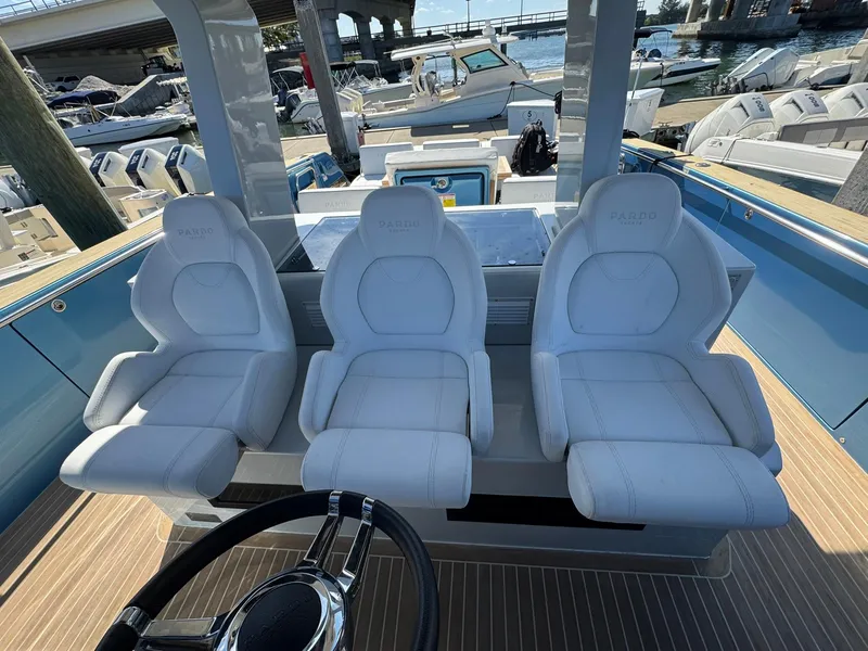 Slide: The Image of Three white captain's chairs on a 2022 Pardo Yachts 43, docked at a marina. - 14