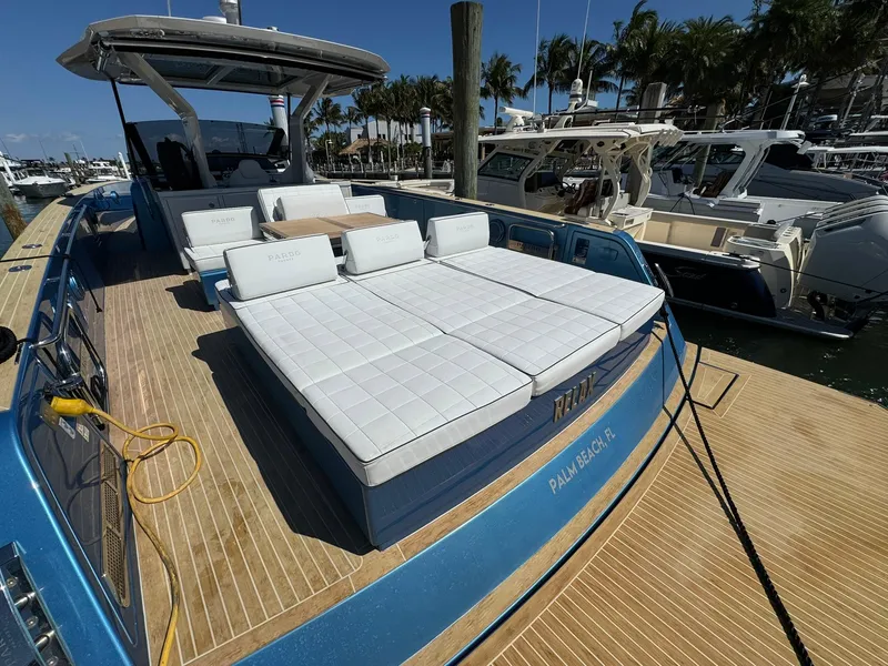 Slide: The Image of 2022 Pardo Yachts 43 with sun loungers, docked at a marina under clear skies. - 2