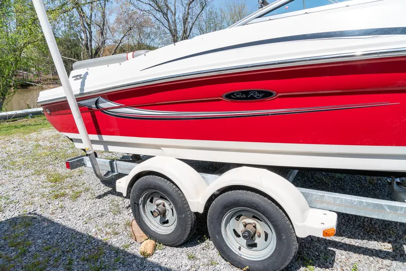 Slide: The Image of 2008 Sea Ray 205 Sport boat on trailer, red and white design, parked outdoors. - 3
