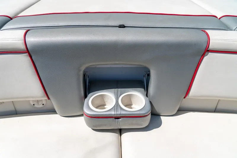 Slide: The Image of 2008 Sea Ray 205 Sport boat interior with dual cup holders and red trim. - 31