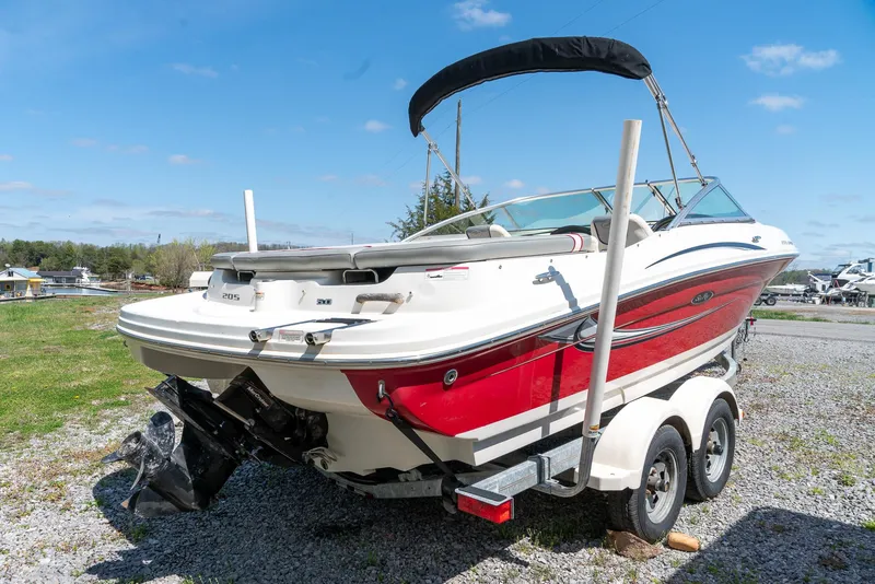 Slide: The Image of 2008 Sea Ray 205 Sport boat on trailer, red and white, parked outdoors. - 4