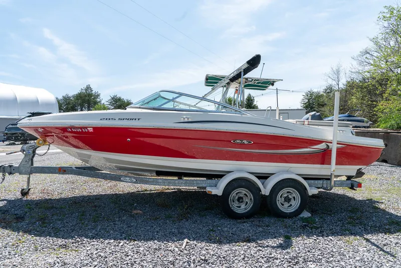 Slide: The Image of 2008 Sea Ray 205 Sport boat on trailer, red and white design, parked outdoors. - 7